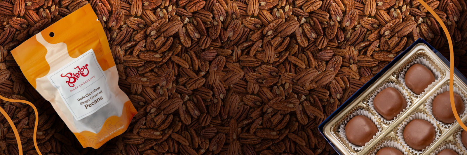 A bag of Brigham’s pecans and a box of chocolate-covered pecan candies rest on a large surface covered with whole pecans.