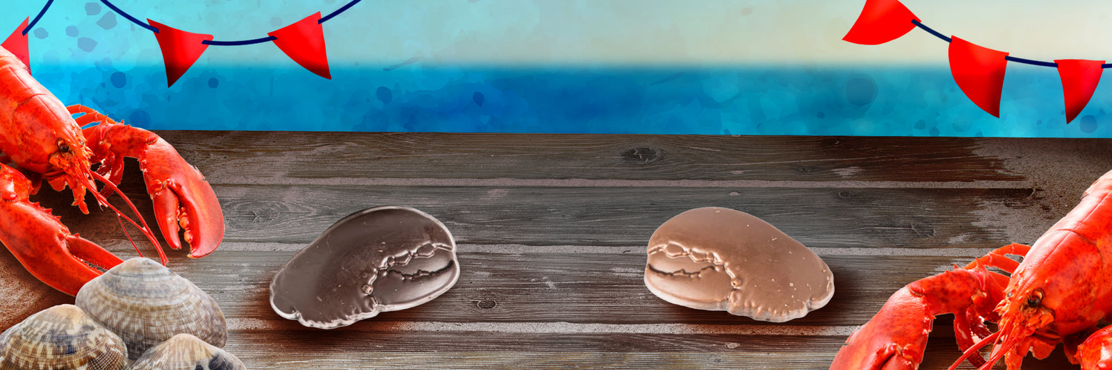Two lobsters and several clams are on a wooden table by the sea, with two chocolate candies in the center and red pennant banners decorating the top. The background shows blue ocean and sky.