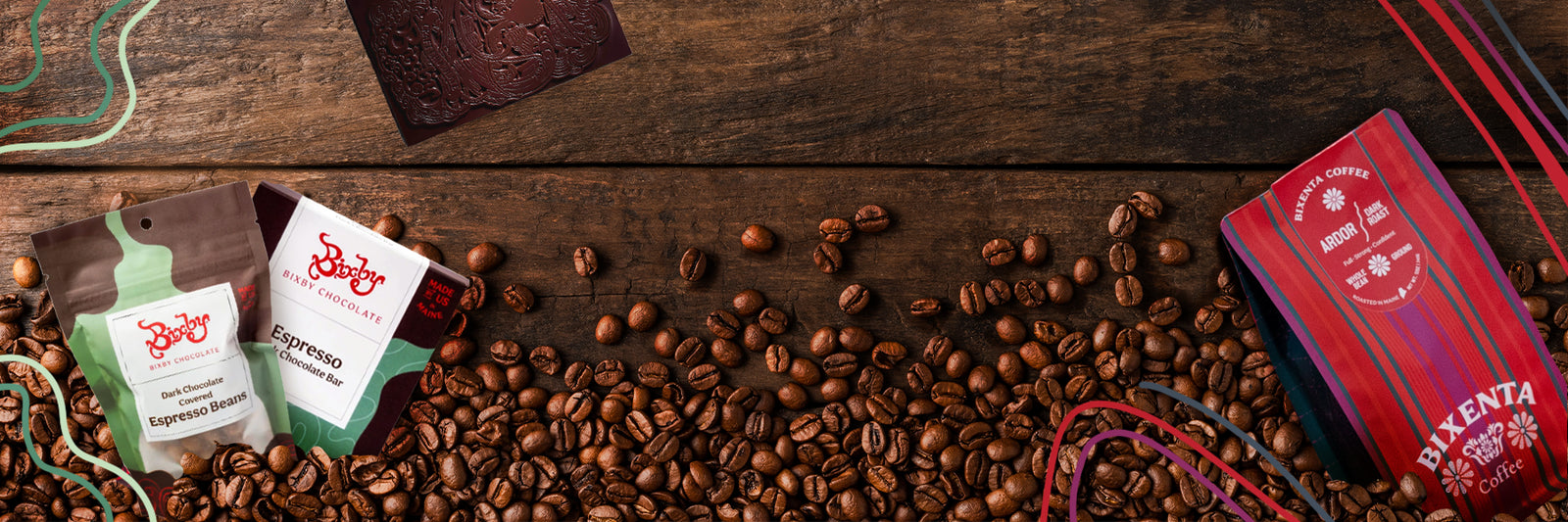 A wooden table scattered with coffee beans, two packets of Brewjoy Espresso Blend, a red-striped coffee card, and colorful abstract lines along the edges.