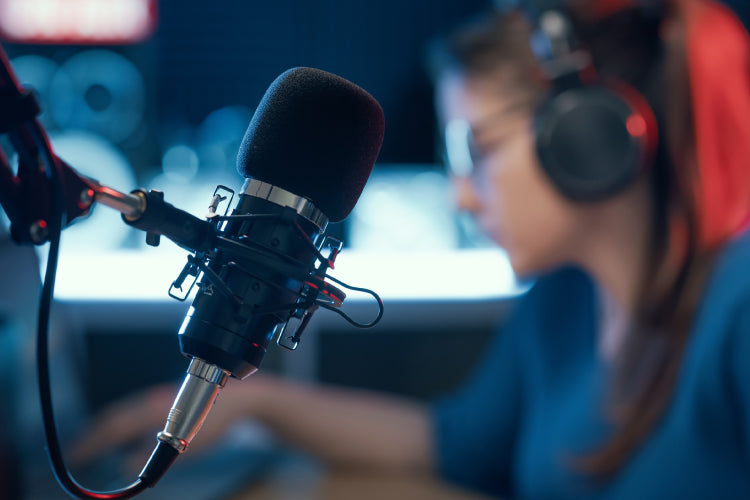Woman in headphones next to a microphone