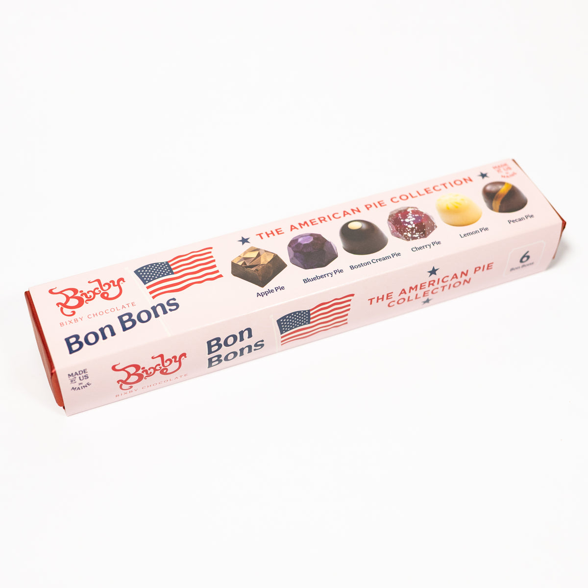 A boxed set of Bon Bons chocolate pie tins from The American Pie Collection, shown on a clean white background. The pink box features illustrations of different chocolate pie tins and American flag graphics.