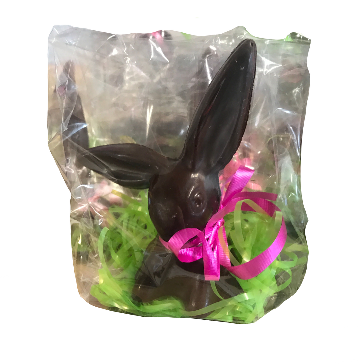 The Bixby Chocolates “Chocolate Bunnies--For Pick Up” features a cute bunny with a pink ribbon, wrapped in clear plastic and nestled in green Easter grass—making it a delightful Easter gift from Rockland, Maine.