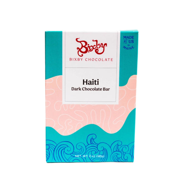A Bixby Chocolates Organic Haitian 70% Dark Chocolate Bar features a vibrant design with blue waves and peach shapes. Made in Maine from Haitian cacao, this bean-to-bar chocolate weighs 2 oz (56g).